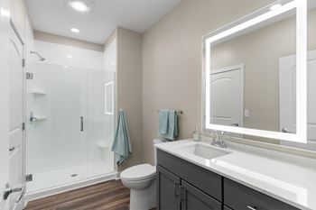 a bathroom with a large mirror and a shower with a glass door